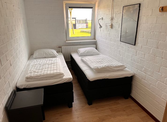 Uitzicht vanuit de woonkamer van Noorderwind vakantiehuis, De Cocksdorp, Texel met grote ramen en tuin.