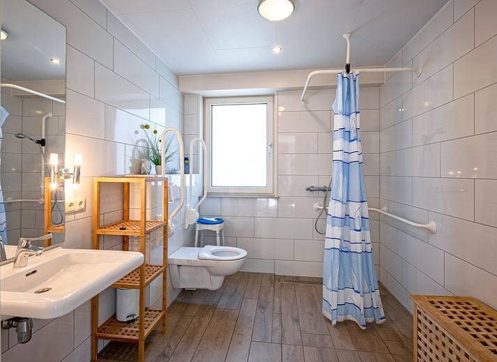 Cozy living room in Holiday home Slufterhoek 174, De Cocksdorp Texel with comfortable chairs and fireplace.