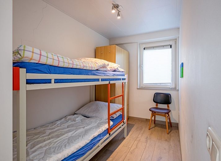 Cozy living room in Holiday home Slufterhoek 174, De Cocksdorp Texel with comfortable chairs and fireplace.