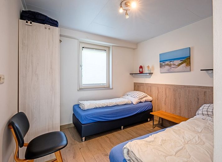 Cozy living room in Holiday home Slufterhoek 174, De Cocksdorp Texel with comfortable chairs and fireplace.