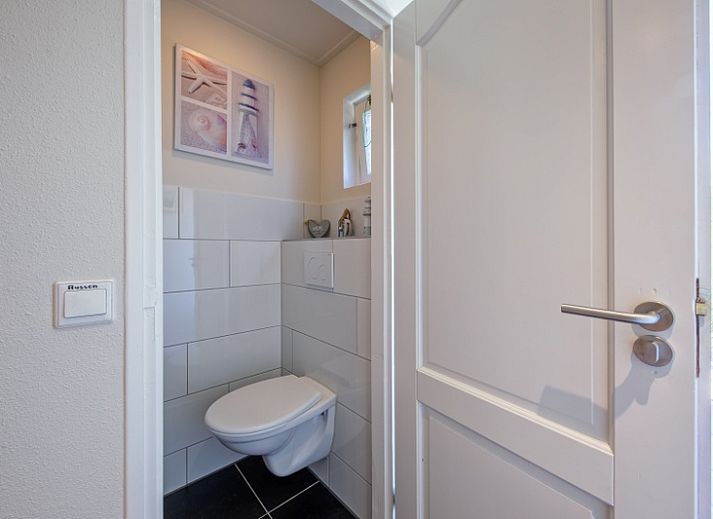 Gezellige woonkamer in Vakantiehuis Slufterhoek 102, De Cocksdorp, Texel met comfortabele bank.