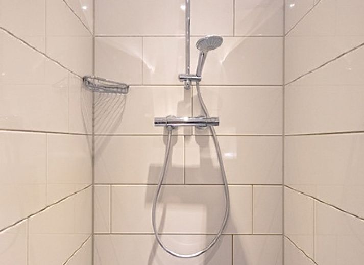 Gezellige woonkamer in Vakantiehuis Slufterhoek 102, De Cocksdorp, Texel met comfortabele bank.