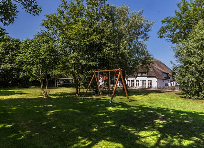 Gezellige woonkamer van Type T-4 vakantiehuis in De Cocksdorp, Texel met houten balken.