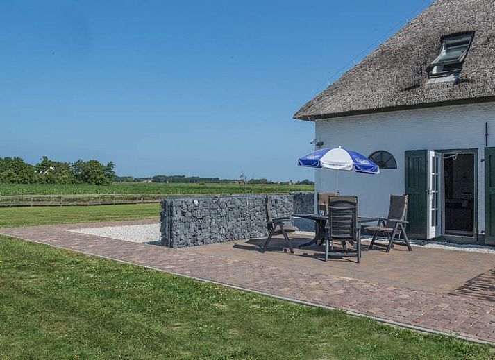 Gezellige woonkamer van Type T-4 vakantiehuis in De Cocksdorp, Texel met houten balken.