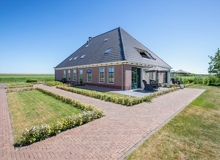 Gezellige eetruimte van Appartement C in De Cocksdorp, Texel met houten tafel en moderne keuken.