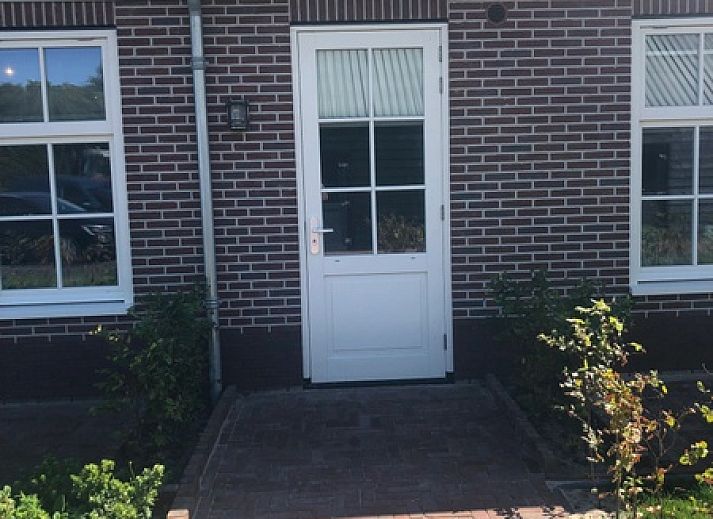 Gezellige eetruimte van Appartement C in De Cocksdorp, Texel met houten tafel en moderne keuken.