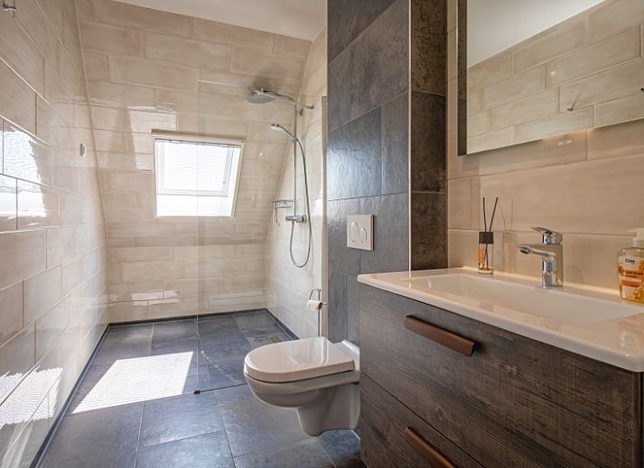 Ruim terras van Appartement C in De Cocksdorp, Texel met uitzicht op groene velden.