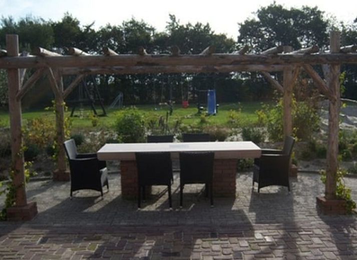 Geraeumiges Wohnzimmer in Cottage in De Cocksdorp, Texel mit Holzinterieur und grossen Fenstern, ideales Ferienhaus auf den Watteninseln.