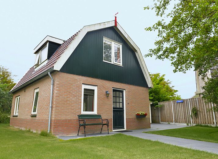 Vuurtorenwachter vakantiehuis in De Cocksdorp, Texel, met charmante bakstenen gevel en groene omgeving.