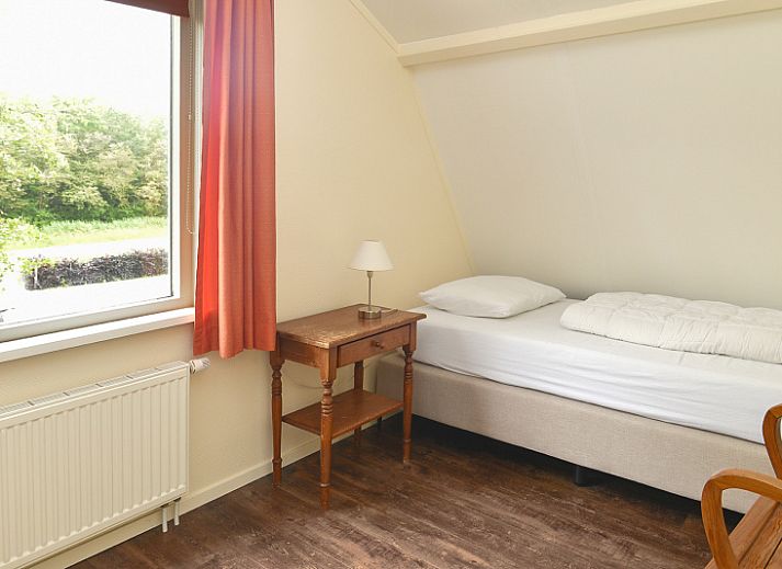 Lichte woonkamer van Vuurtorenwachter vakantiehuis in De Cocksdorp, Texel, met uitzicht op de tuin.