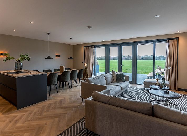 Lichte woonkamer Princenhof 3 in De Cocksdorp Texel met uitzicht op het landschap.