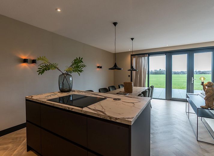 Lichte woonkamer Princenhof 3 in De Cocksdorp Texel met uitzicht op het landschap.