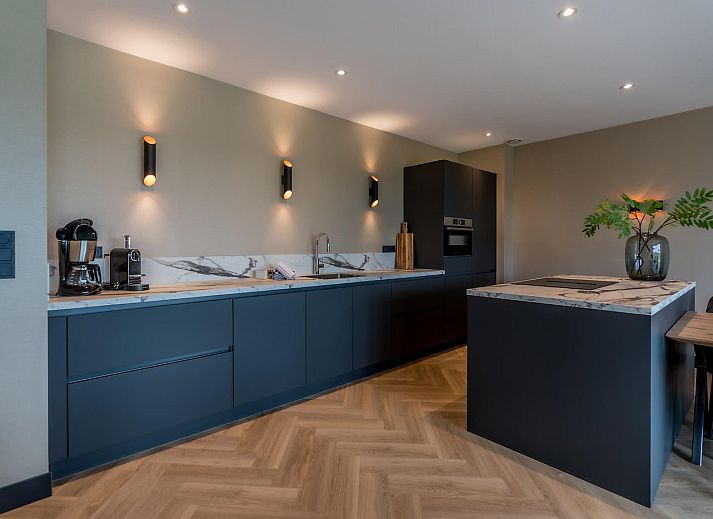 Lichte woonkamer Princenhof 3 in De Cocksdorp Texel met uitzicht op het landschap.