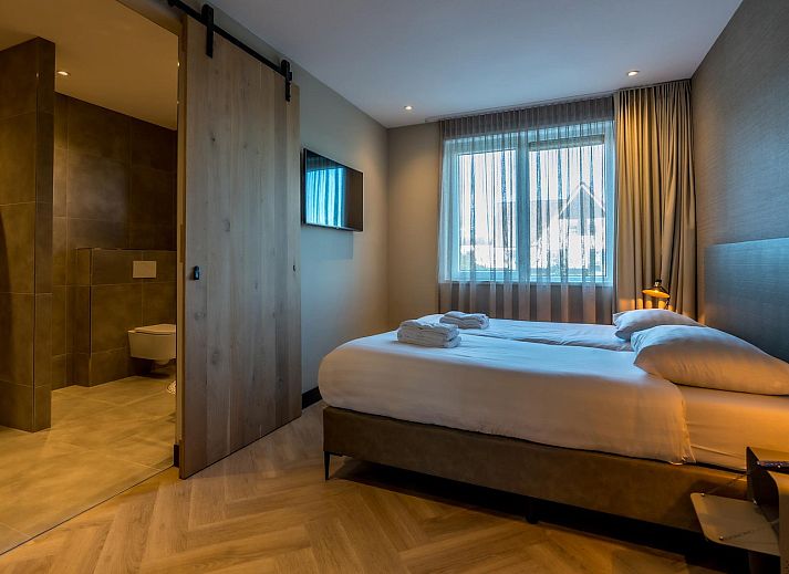 Lichte woonkamer Princenhof 3 in De Cocksdorp Texel met uitzicht op het landschap.