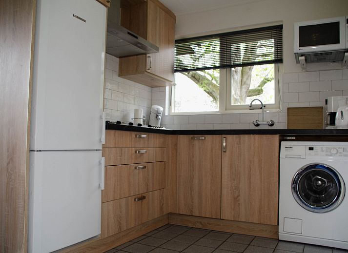 Ingang van 9600 - Daalder - Troost in De Cocksdorp Texel, vakantiehuis met blauwe poort en weelderige heg.