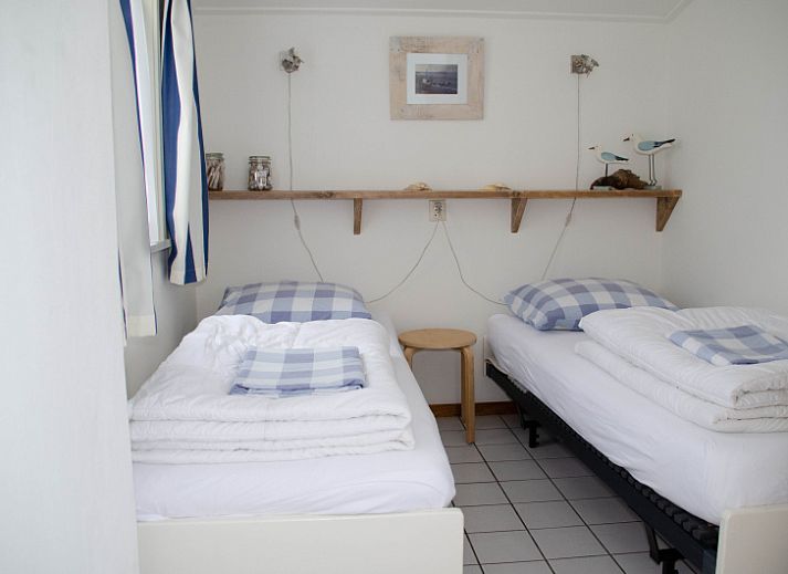 Ingang van 9600 - Daalder - Troost in De Cocksdorp Texel, vakantiehuis met blauwe poort en weelderige heg.