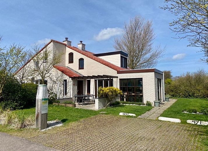 Vakantiehuis D 491 in De Cocksdorp, Texel met zonnige veranda en groene omgeving, ideaal voor een ontspannen verblijf op de Waddeneilanden.