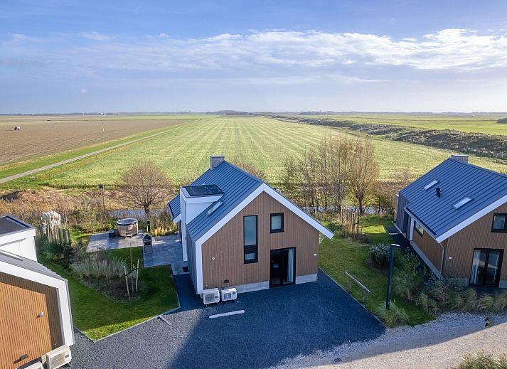 Luftaufnahme eines freistehenden Hauses in De Cocksdorp, Texel, umgeben von Natur und modernen Ferienhusern auf den Watteninseln.