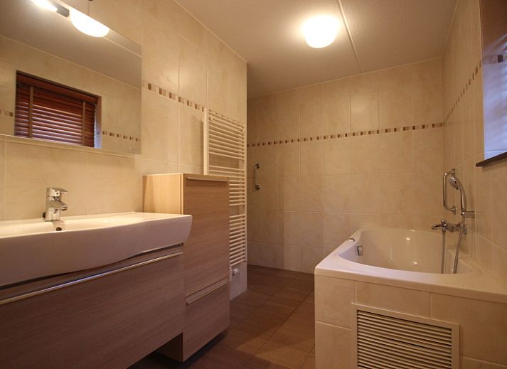 Gezellige woonkamer in Villa De Witte Hoek, De Cocksdorp, Texel met comfortabele zithoek en open haard voor een ontspannen verblijf.