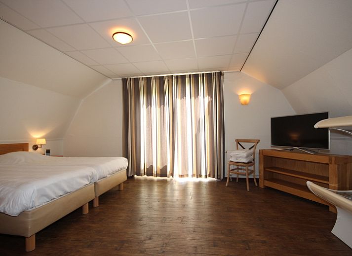 Gezellige woonkamer in Villa De Witte Hoek, De Cocksdorp, Texel met comfortabele zithoek en open haard voor een ontspannen verblijf.