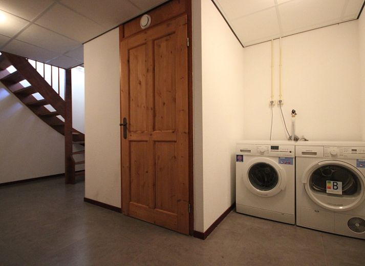 Gezellige woonkamer in Villa De Witte Hoek, De Cocksdorp, Texel met comfortabele zithoek en open haard voor een ontspannen verblijf.