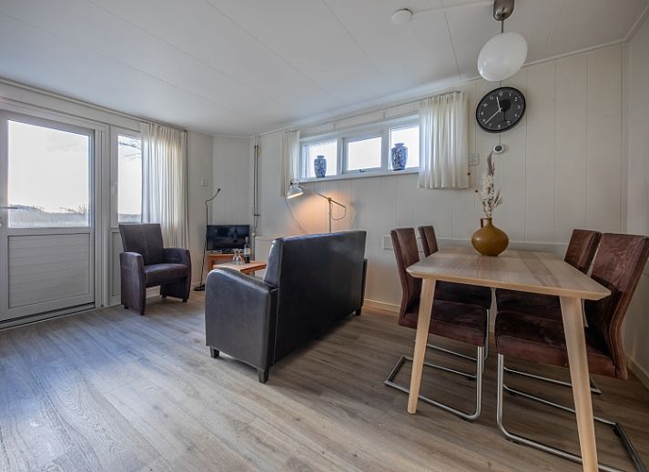 Rustikales Ferienhaus Kikkertstraat 60 in De Cocksdorp, Texel mit Holzfassade und gruener Umgebung.