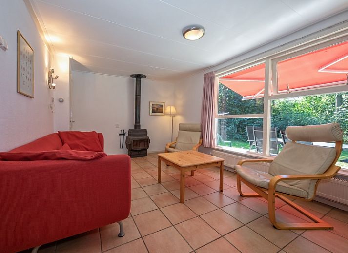 Vakantiehuis Slufterduin 088 in De Cocksdorp, Texel, omgeven door groene natuur en een zonnig terras.