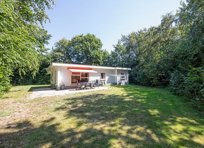 Ruime binnenruimte van Vakantiehuis Slufterduin 088 in De Cocksdorp, Texel, met een rode bank en eetgedeelte.