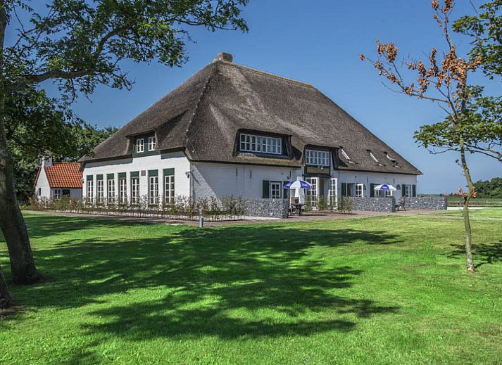 Type R vakantiehuis in De Cocksdorp, Texel met rieten dak en groene tuin, Waddeneilanden.