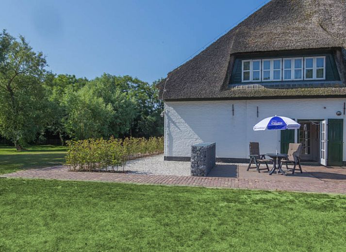 Gezellige woonkamer in Type R vakantiehuis, De Cocksdorp, Texel, met grote ramen en comfortabele zitplaatsen.