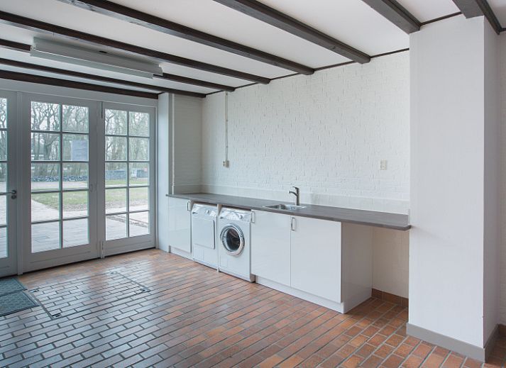 Gezellige woonkamer in Type R vakantiehuis, De Cocksdorp, Texel, met grote ramen en comfortabele zitplaatsen.