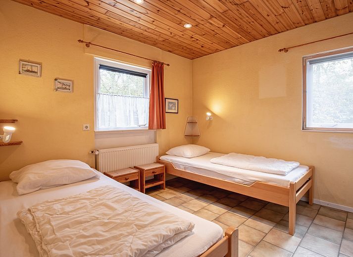 Cozy living room of Holiday home Slufterduin 094 in De Cocksdorp, Texel, with comfortable seating area and views of the green garden.