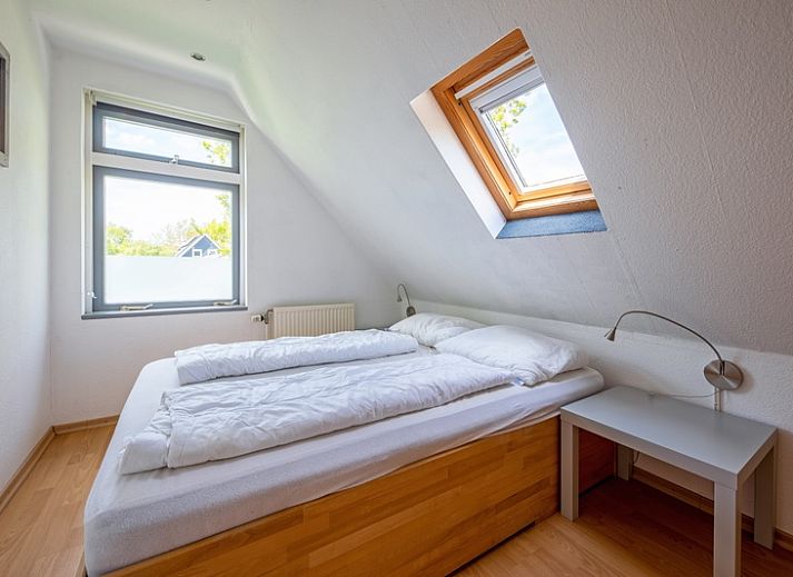 Lichte woonkamer van Vakantiehuis Slufterhoek 158 in De Cocksdorp, Texel, met moderne inrichting en uitzicht op de tuin.