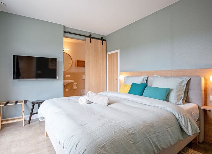 Cozy living room with large window in Holiday home De Razende Bol, De Cocksdorp, Texel, overlooking the garden.