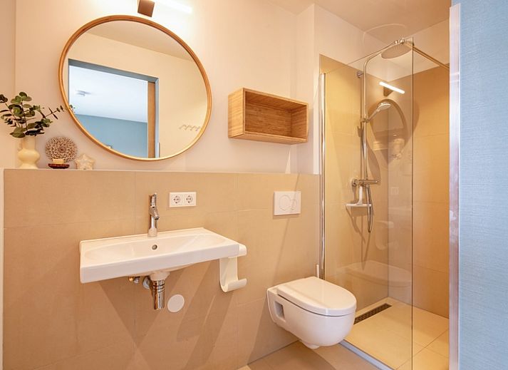 Cozy living room with large window in Holiday home De Razende Bol, De Cocksdorp, Texel, overlooking the garden.