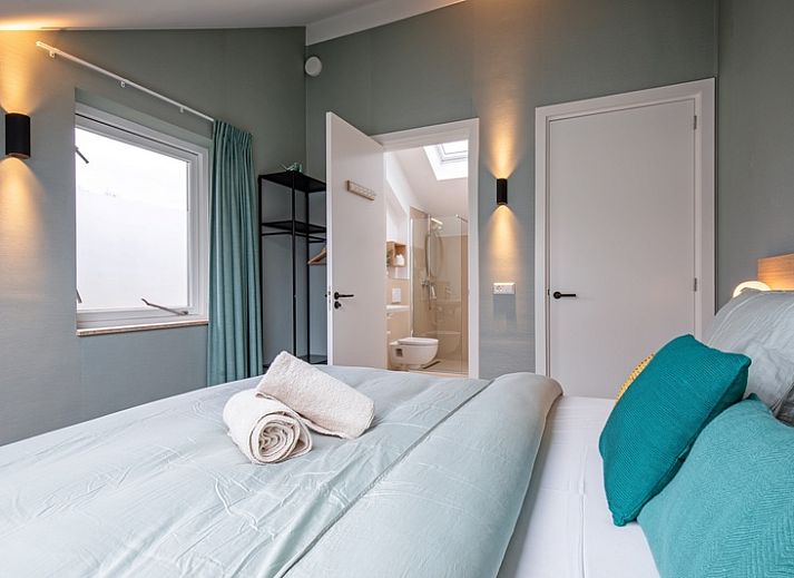 Cozy living room with large window in Holiday home De Razende Bol, De Cocksdorp, Texel, overlooking the garden.