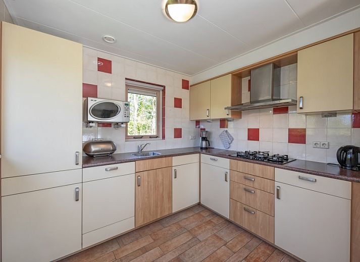 Ferienhaus in Sued-Eierland, Texel, mit sonniger Auffahrt und gruener Umgebung.