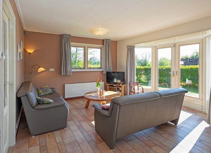 Ferienhaus in Sued-Eierland, Texel, mit sonniger Auffahrt und gruener Umgebung.