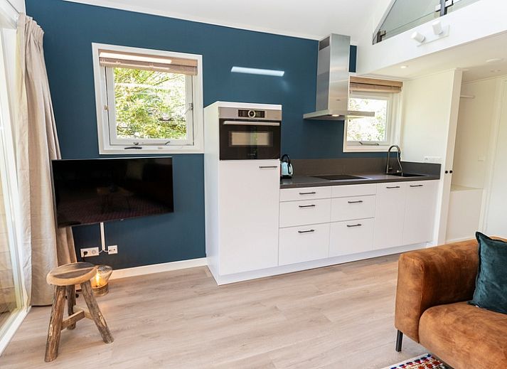 Gemuetliches Ferienhaus Zeewinde in De Cocksdorp, Texel, mit einer einladenden Terrasse und gruener Umgebung.