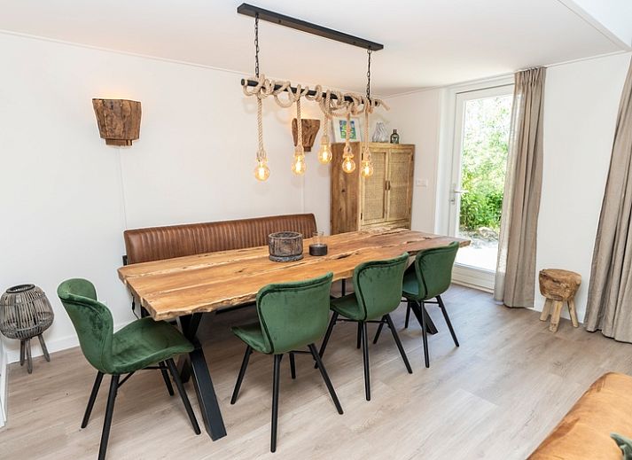 Gemuetliches Ferienhaus Zeewinde in De Cocksdorp, Texel, mit einer einladenden Terrasse und gruener Umgebung.