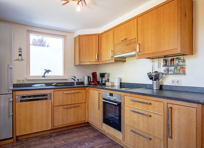 Gezellige buitenruimte bij Vakantiehuis Ganzenvlucht, De Cocksdorp Texel, omgeven door bloemen.