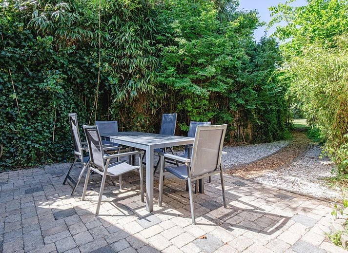 Gezellige buitenruimte bij Vakantiehuis Ganzenvlucht, De Cocksdorp Texel, omgeven door bloemen.