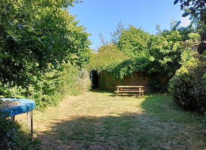 Gezellige buitenruimte bij Vakantiehuis Ganzenvlucht, De Cocksdorp Texel, omgeven door bloemen.