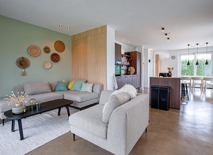 Gezellige woonkamer van Vakantiehuis Brakzand in De Cocksdorp, Texel, met uitzicht op de tuin en moderne inrichting.