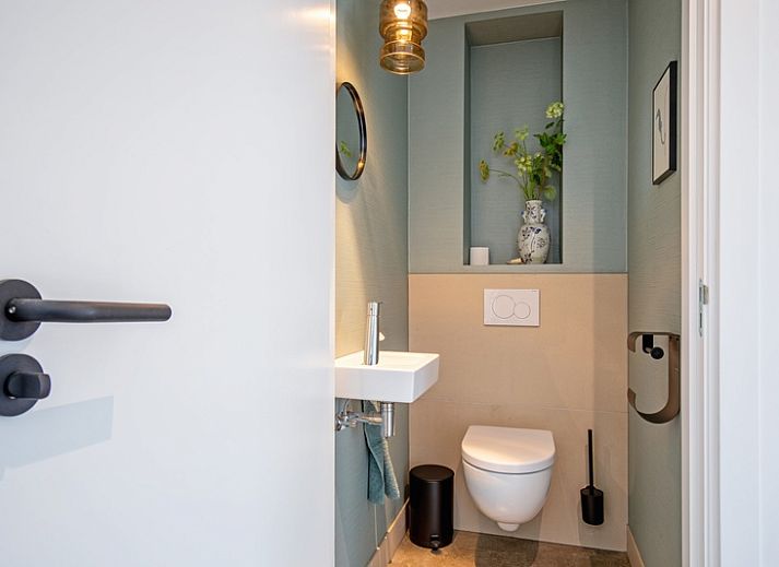 Gezellige woonkamer van Vakantiehuis Brakzand in De Cocksdorp, Texel, met uitzicht op de tuin en moderne inrichting.