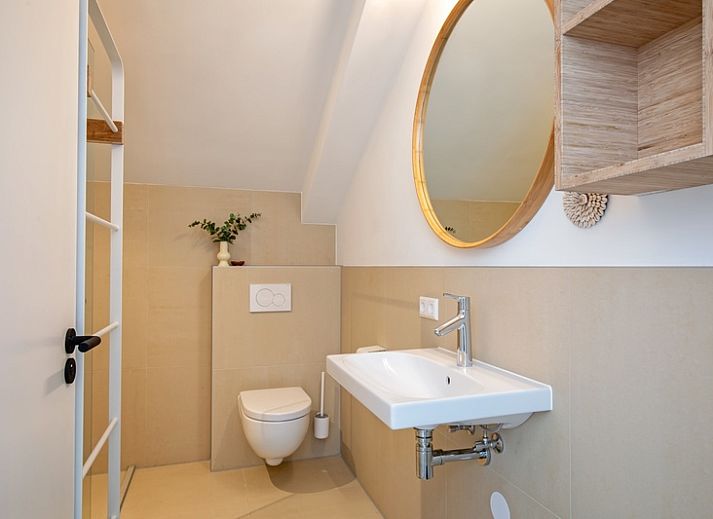 Stijlvolle binnenruimte van Vakantiehuis Brakzand in De Cocksdorp, Texel, met comfortabele zithoek en open keuken.