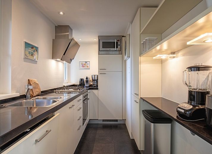 Gemuetliches Wohnzimmer im Ferienhaus Noordhoorn, gelegen in De Cocksdorp, Texel. Gemuetliche Sitzecke mit Blick auf den Garten.