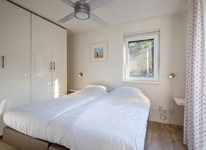 Gemuetliches Wohnzimmer des Ferienhauses Noordhoorn in De Cocksdorp, Texel mit komfortabler Einrichtung und Blick auf den gruenen Garten.