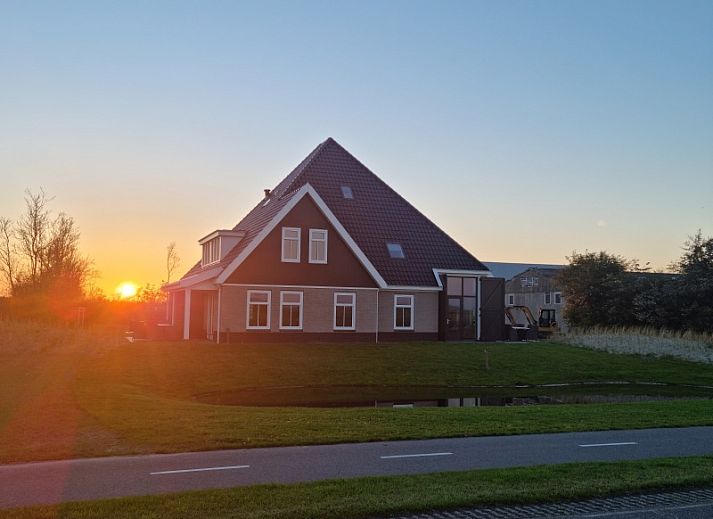 Vakantiehuis Eierland in De Cocksdorp, Texel biedt een prachtig uitzicht op de natuur met een vijver en groene omgeving.