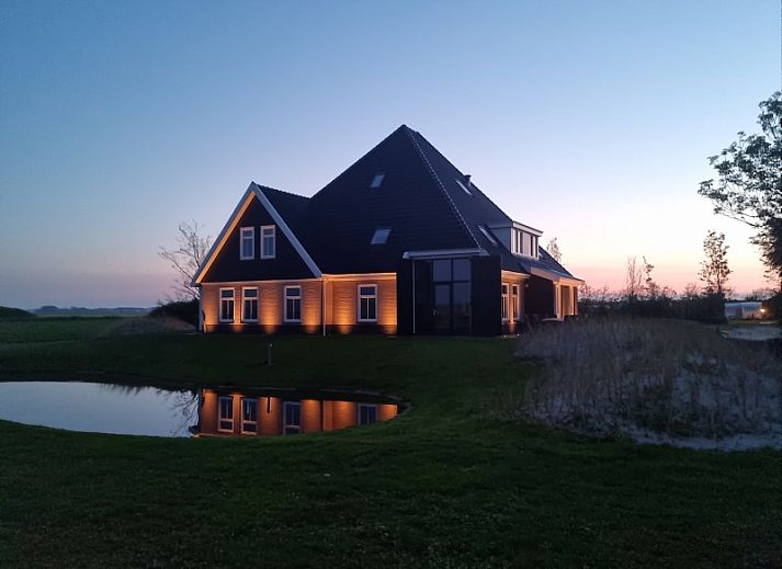 Vakantiehuis Eierland in De Cocksdorp, Texel biedt een prachtig uitzicht op de natuur met een vijver en groene omgeving.